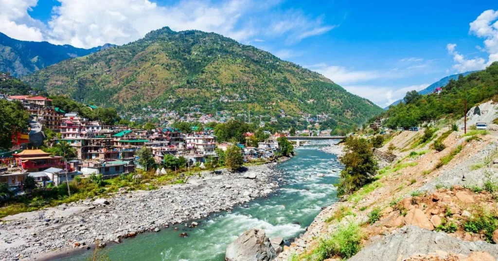 Family rafting on the Beas River surrounded by green valleys in Kullu.